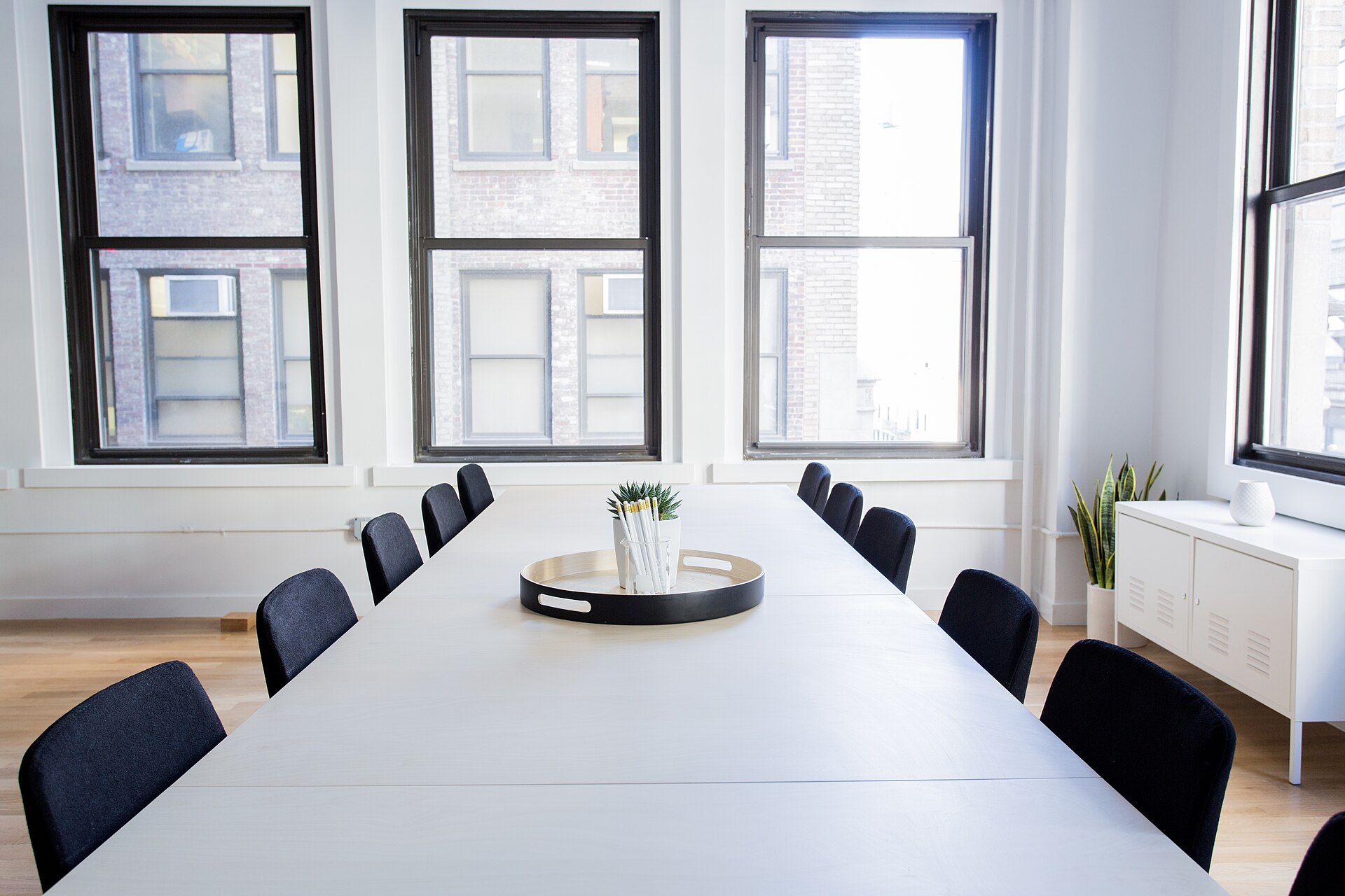 An empty meeting room, chairs drawn up to a long table, no one present.